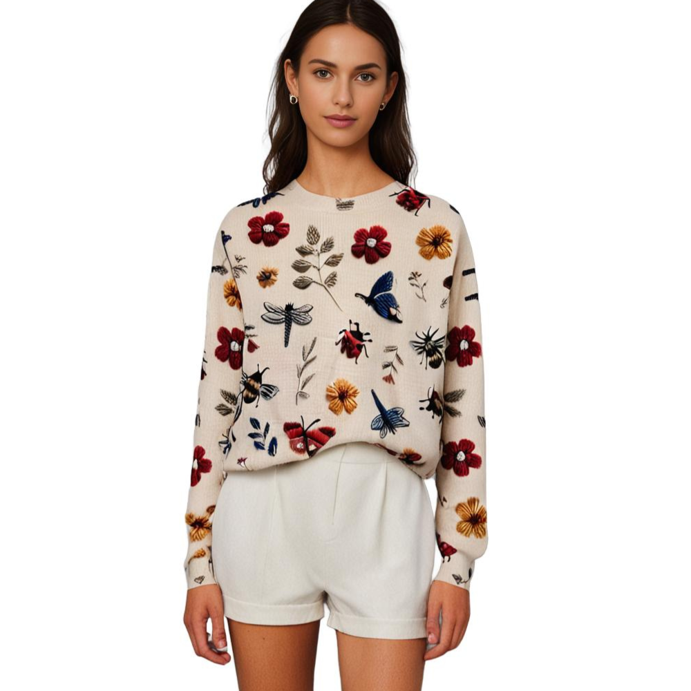 Frau in cremefarbenem Pullover mit Blumenmuster und weißen Shorts, modisch, elegant.