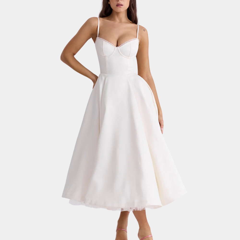 Frau in weißem, ärmellosem Cocktailkleid mit Herzausschnitt, elegantes Abendmode-Design.