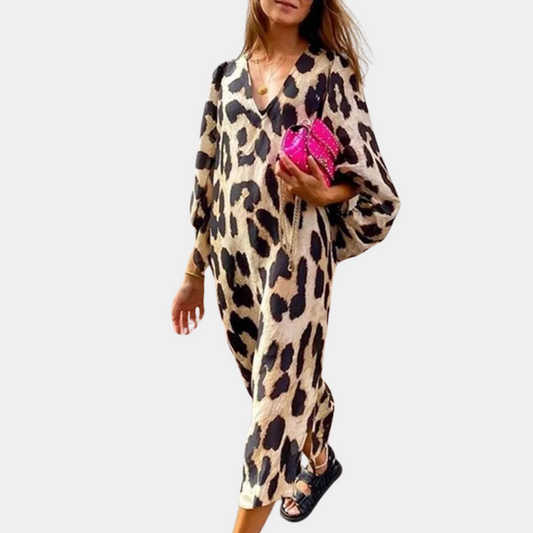 Frau in beige-schwarzem Leopardenkleid, trägt pinke Tasche, modisch, elegant, lässiger Stil.