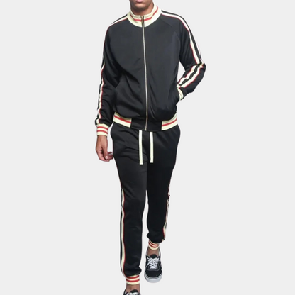 Mann in schwarzem Trainingsanzug mit Streifen, Reißverschlussjacke, Freizeithose, Sneakers.