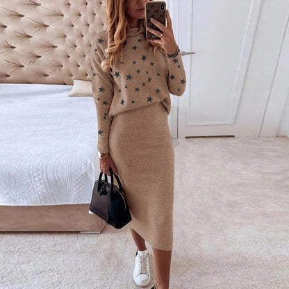 Frau in beigem Strickkleid mit Sternenmuster, schwarze Tasche, weiße Sneaker, modernes Schlafzimmer.