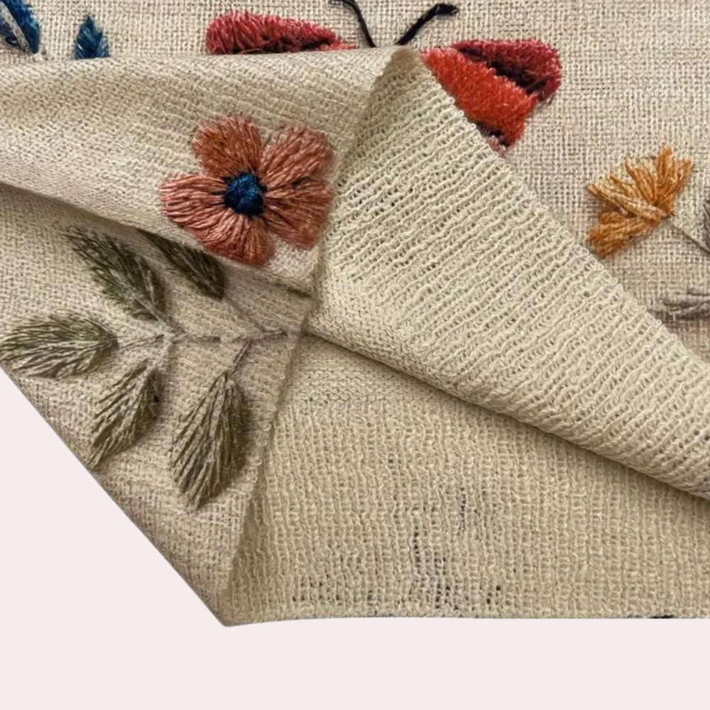 Bestickter beiger Stoff mit Blumen- und Schmetterlingsmuster, handgefertigt, dekorativ.