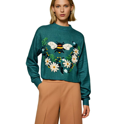 Frau in blauem Pullover mit Bienen- und Blumenmuster, modisch, Herbstmode, Damenbekleidung.