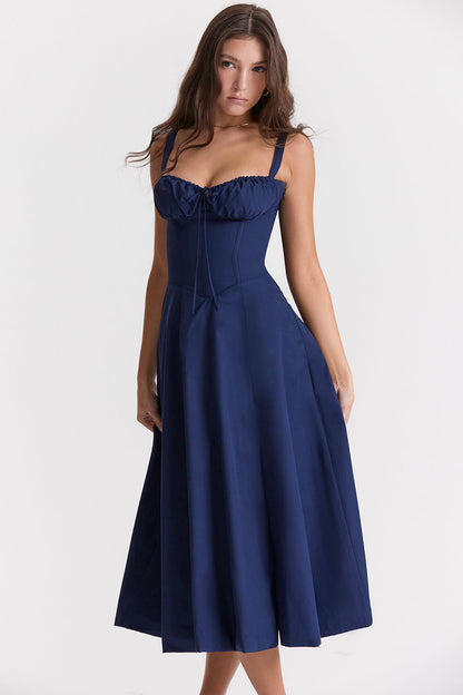Frau in dunkelblauem, ärmellosem Kleid, elegantes Design, knielang, Modefotografie.