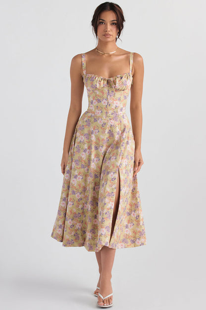 Frau in geblümtem Sommerkleid mit Schlitz, pastellfarben, ärmellos, elegantes Design.