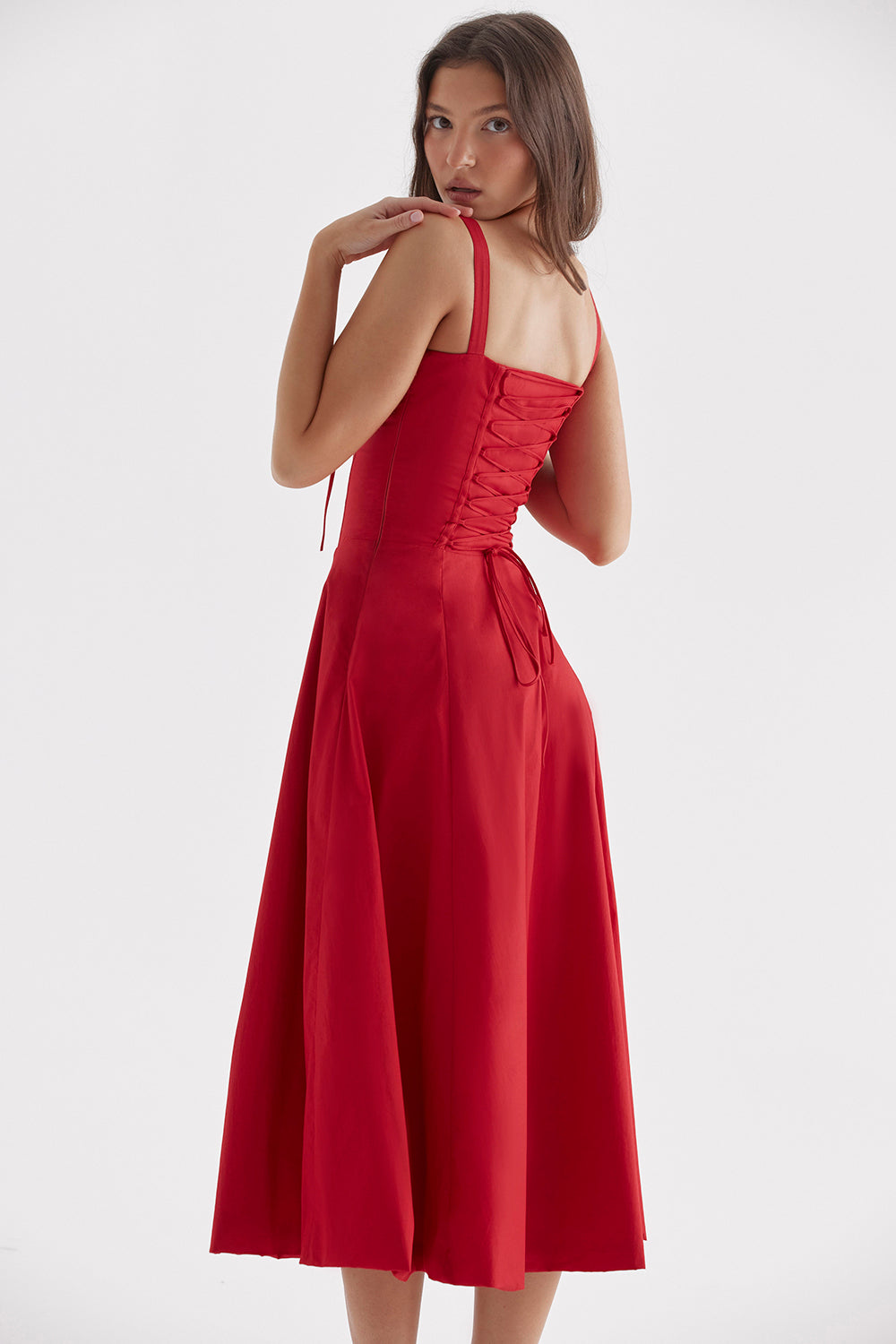 Frau in rotem, ärmellosem Kleid mit Schnürung, knielang, elegantes Abendkleid, Modefotografie.