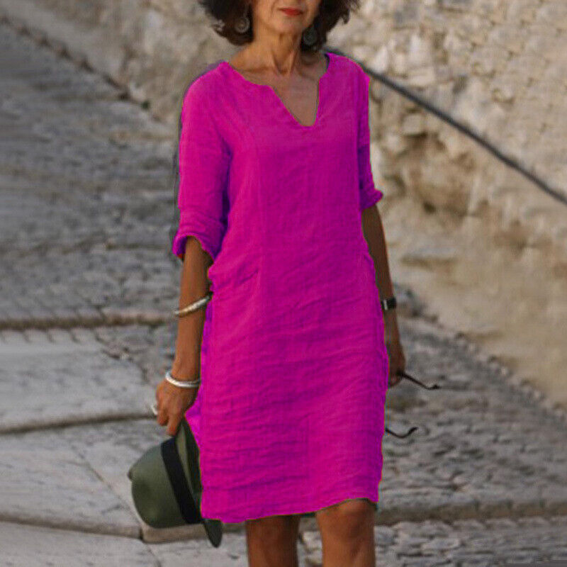 Frau in pinkem Leinenkleid, Sommermode, lässig, V-Ausschnitt, Spaziergang, Steinweg.