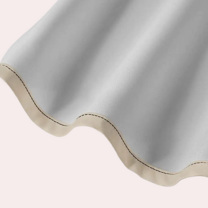Graues, wellenförmiges Leder mit beiger Naht, Nahaufnahme, hochwertiges Material.